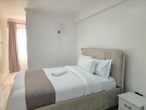 a bedroom with a bed with white sheets and a window at Marie's 2bed all-ensuite Tuffoam 310 in Kisumu