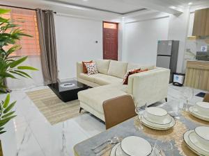 a living room with a couch and a table at Marie's 2bed all-ensuite Tuffoam 310 in Kisumu