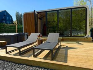 two chairs and a table on a deck at Romantic tiny Pod for Two HotTub Pond FirePit in Haines Falls