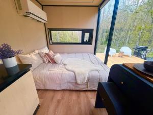 a bedroom with a bed and a large window at Romantic tiny Pod for Two HotTub Pond FirePit in Haines Falls