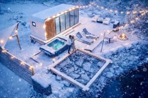 a person standing in front of a trailer in the snow at Romantic tiny Pod for Two HotTub Pond FirePit in Haines Falls