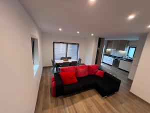 a living room with a red couch and a table at Casa do Rio in Freixieiro de Soutelo