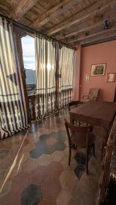 a room with a table and chairs and large windows at Antica osteria in Primaluna
