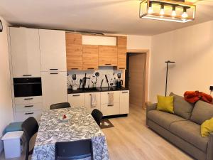 a living room with a couch and a table and a kitchen at Casa D'Ambros - Cadore in Santo Stefano di Cadore