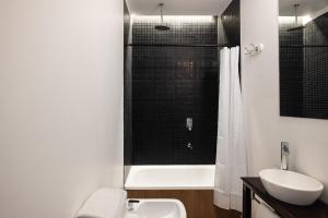 a bathroom with a toilet and a sink and a shower at Acassuso Suites in Acassuso +102 photos