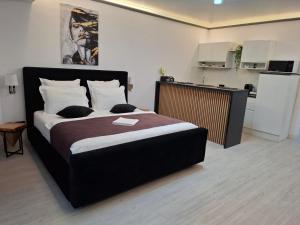 a bedroom with a large bed and a kitchen at White Titanic 322 in Mamaia Sat/Năvodari