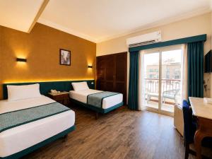 a hotel room with two beds and a balcony at St George Hotel - The Zoo in Cairo +43 photos