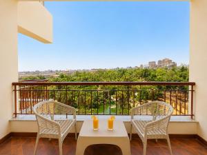 a balcony with two chairs and a table with orange candles at St George Hotel - The Zoo in Cairo