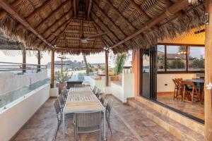 an outdoor dining area with tables and chairs at Rooftop Oasis Steps from the Malecon in La Paz