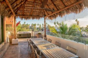 a patio with tables and chairs and a large window at Rooftop Oasis Steps from the Malecon in La Paz