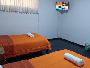 a room with two beds and a table and a tv at HOTEL BOUTIQUE TerrazaINN in Arequipa +12 photos