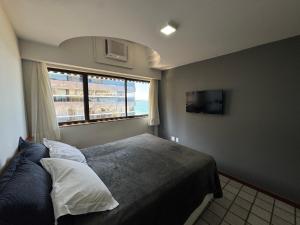 a bedroom with a large bed and a window at Flats beira mar - praia da costa in Vila Velha +19 photos