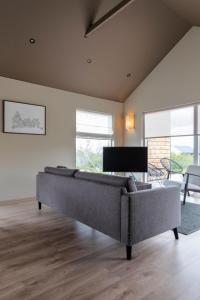 a living room with a couch and a piano at Modern Cabin with Hot Tub & Mountain views in Varmaland