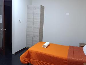 a bedroom with an orange bed with a towel on it at HOTEL BOUTIQUE TerrazaINN in Arequipa