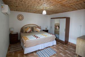 a bedroom with a large bed with a wooden ceiling at Karrizo lodge in San Pedro de Atacama