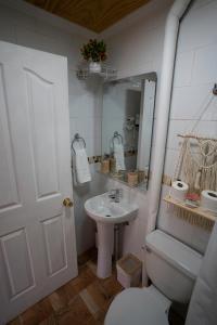 a bathroom with a sink and a toilet and a mirror at Karrizo lodge in San Pedro de Atacama +31 photos