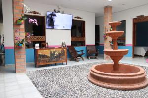 a lobby with a fountain in the middle of a room at Hotel Barajas in Jardin