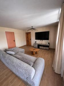 a living room with a couch and a flat screen tv at Villa R-A in Kourou