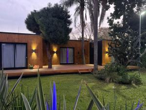 a small house with a wooden deck in a yard at Bio Espacio in Belén de Escobar