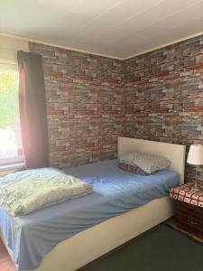 a bed in a room with a brick wall at Omran House in Ystad