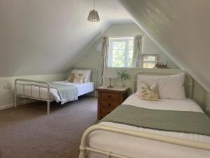 a bedroom with two beds and a window at Breach Lodge in Bonvilston
