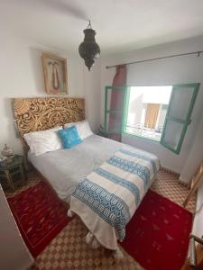 a bedroom with a bed and a window at Over Sea Taghazout in Taghazout