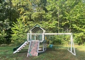 a playground with a swing set in a yard at Autumn Wings - Propane Grill, Wifi, Kid Friendly, King Bed, Games, Screen Porch, Pool Access, Hiking in Berkeley Springs