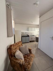 a living room with a couch and a kitchen at Studio Planejado no Centro de Campos Novos in Campos Novos