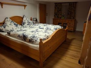 a bedroom with a wooden bed with blue and white sheets at Haus Semmelrodt in Witzenhausen