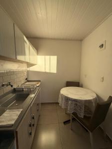 a small kitchen with a table and a sink at Studio Planejado no Centro de Campos Novos in Campos Novos