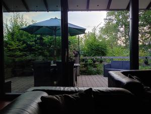 a living room with a couch and an umbrella at vakantieverblijf Coo-sy in Stavelot +42 photos