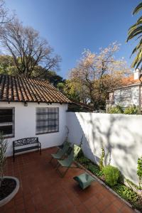 a patio with a bench and a house at Acassuso Suites in Acassuso