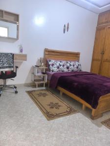 a bedroom with a bed and a desk at Sara guest house in Agadir