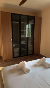 a white bed with two towels on top of it at Villa Ulu Piqeras in Piqeras