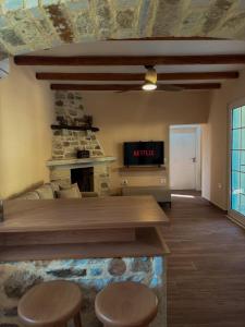a living room with a stone fireplace and a tv at Villa Ulu Piqeras in Piqeras