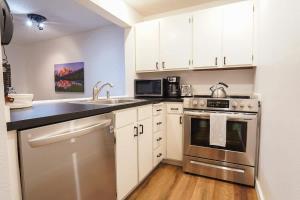 a kitchen with stainless steel appliances and white cabinets at Mt Baker Den, Sleeps 4 in Glacier