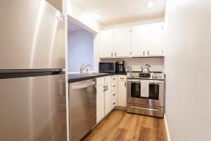 a kitchen with white cabinets and stainless steel appliances at Mt Baker Den, Sleeps 4 in Glacier +24 photos