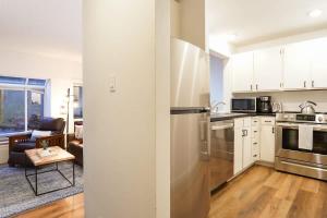 a kitchen with stainless steel appliances and a living room at Mt Baker Den, Sleeps 4 in Glacier