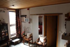 a living room with two chairs and a window at Vilar dos Condes in Madeirã