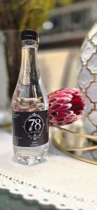 a bottle of water on a table next to a flower at 78onJean in Centurion
