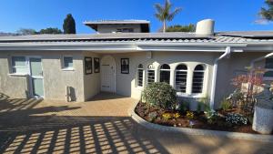 a small white house with a driveway at 78onJean in Centurion