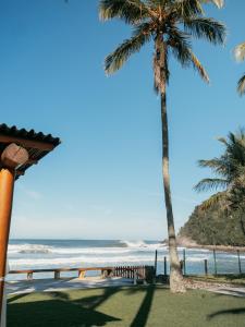 a view of the beach with two palm trees at Olisa Al Mar in Maresias