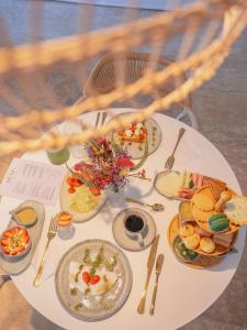 a white table with plates of food on it at Olisa Al Mar in Maresias