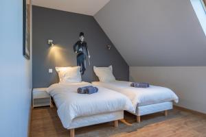 two beds in a room with a statue on the wall at residence kersailliou in Roscoff