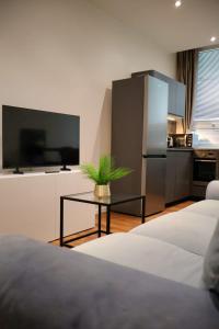a living room with two beds and a table with a tv at Apartman Deluxe Astrova B in Bratislava