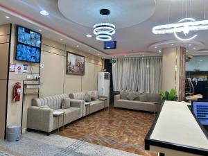 a waiting room with couches and a flat screen tv at Johraat Taba Tourist Hostel in Medina