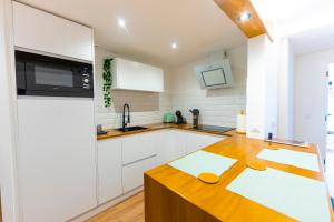 a kitchen with white cabinets and a wooden counter top at LAR DE SEFA in Redondela
