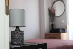 a lamp sitting on a table next to a bed at Heleni's Apartment in Aridaia