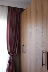 a room with a curtain and a wooden cabinet at Heleni's Apartment in Aridaia