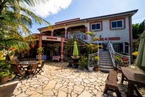 a house with a patio with tables and chairs at Fleur de vanille in Le Tampon